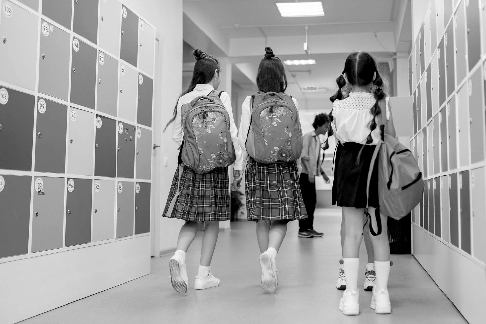 Students with backpacks walking down a school corridor